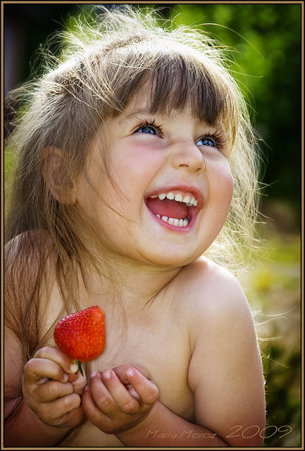 baby with strw bery in hand